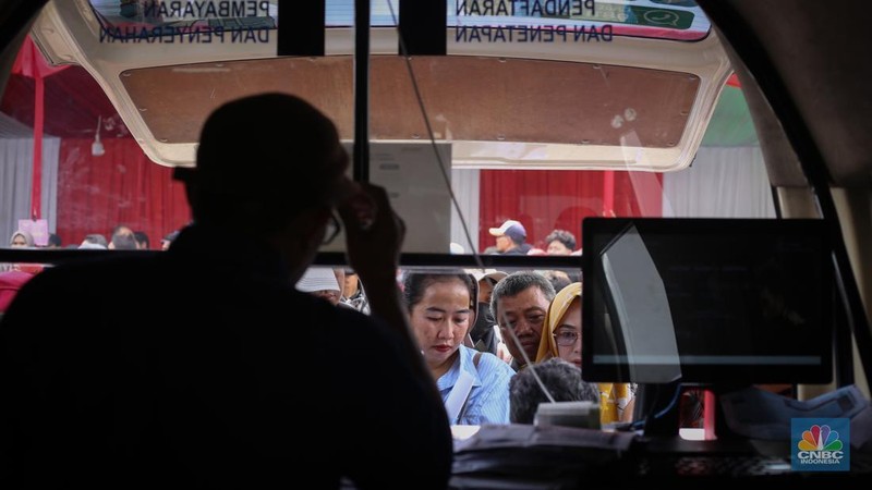 Antrean mengular puluhan kendaraan untuk melakukan pengurusan pajak kendaraan di Samsat Kota Bekasi, Jl. Insinyur H. Juanda, Bekasi, Jawa Barat, Jumat (21/3/2025). (CNBC Indonesia/Tias Budiarto)