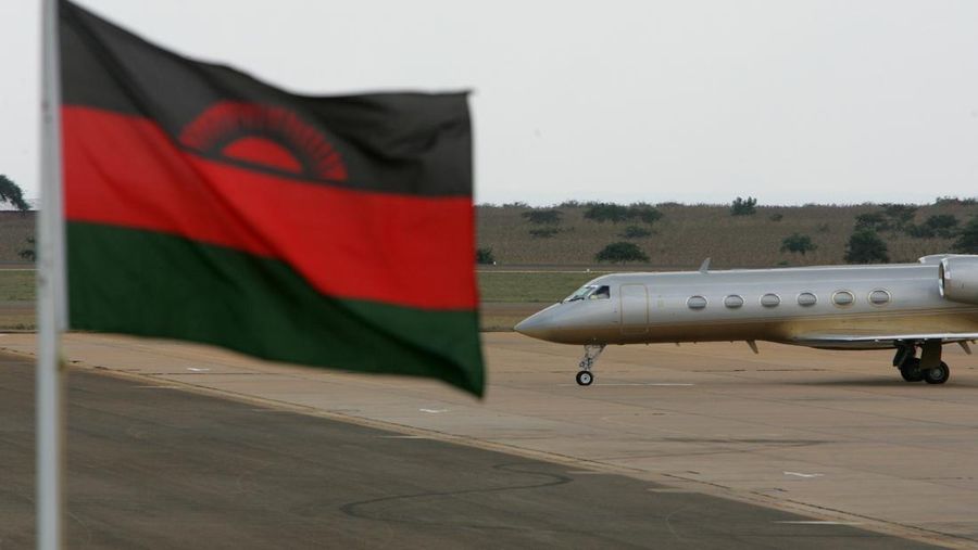 Sebuah jet pribadi yang membawa penyanyi AS Madonna meluncur di landasan pacu dengan bendera Malawi di latar depan di bandara internasional Kamuzu di Lilongwe, Malawi, Minggu, 22 April 2007. (AP Photo/Karel Prinsloo/File Foto)