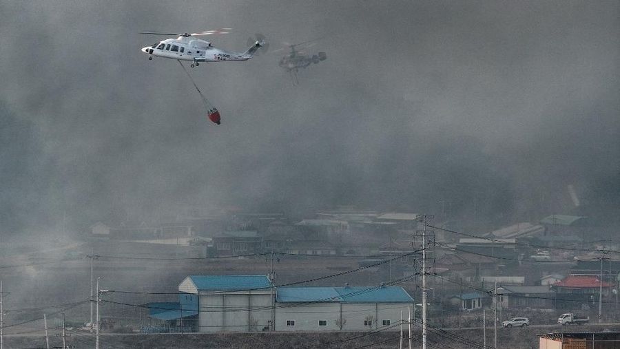Petugas pemadam kebakaran memadamkan api di bangunan pabrik yang dilalap api hutan di Uiseong, Korea Selatan, Sabtu, 22 Maret 2025. (Yoon Gwan-shick/Yonhap via AP)