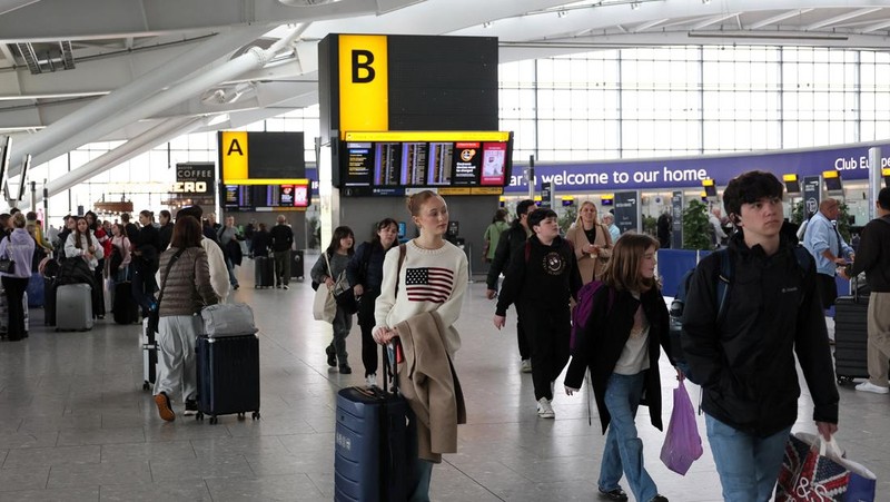 Orang-orang berjalan di Terminal 5 Bandara Internasional Heathrow, sehari setelah kebakaran di gardu listrik di dekatnya yang memutus aliran listrik di bandara, dekat London, Inggris, 22 Maret 2025. (REUTERS/Isabel Infantes)