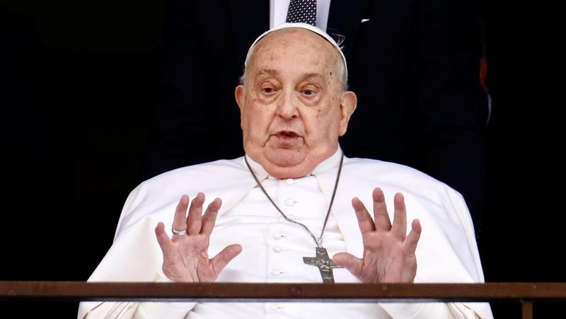 Orang-orang menonton Paus Fransiskus selama penampilan publik pertamanya dalam lima minggu, di layar lebar di Lapangan Santo Petrus, di Vatikan, 23 Maret 2025. (REUTERS/Matteo Minnella)