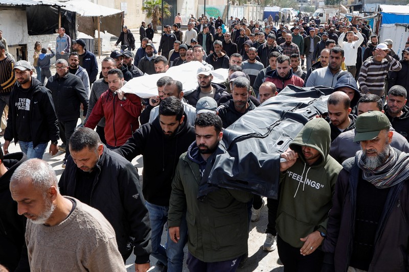 Warga Palestina menghadiri pemakaman pemimpin politik Hamas Salah al-Bardaweel dan istrinya, yang tewas dalam serangan Israel di tenda perlindungan mereka, di Khan Younis di Jalur Gaza selatan, 23 Maret 2025. (REUTERS/Hatem Khaled)