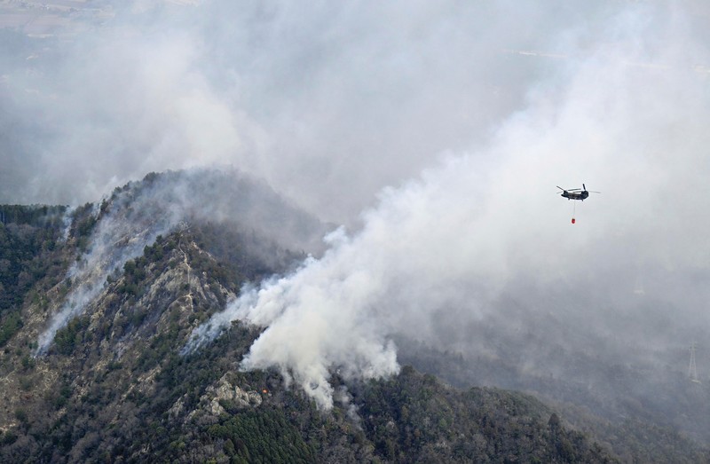Smoke rises from a forest in Okayama, western Japan Sunday, March 23, 2025. (Kyodo News via AP)
