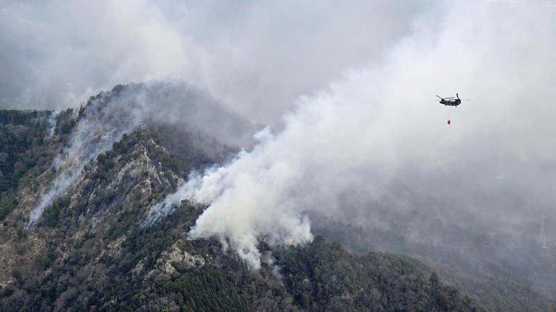 Smoke rises from a forest in Okayama, western Japan Sunday, March 23, 2025. (Kyodo News via AP)