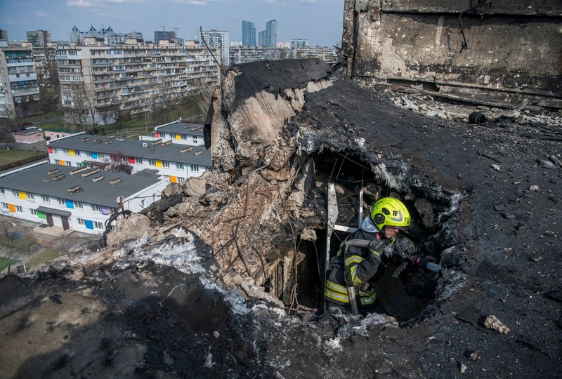 Seorang petugas pemadam kebakaran bekerja di lokasi gedung apartemen yang terkena serangan pesawat nirawak Rusia, di tengah serangan Rusia terhadap Ukraina, di Kyiv, Ukraina, 23 Maret 2025. (via REUTERS/STATE EMERGENCY SERVICE OF UKRAI)