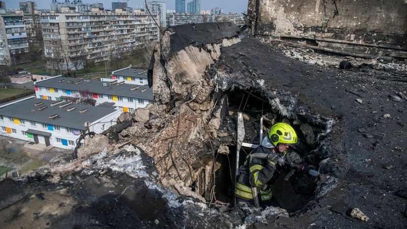 Seorang petugas pemadam kebakaran bekerja di lokasi gedung apartemen yang terkena serangan pesawat nirawak Rusia, di tengah serangan Rusia terhadap Ukraina, di Kyiv, Ukraina, 23 Maret 2025. (via REUTERS/STATE EMERGENCY SERVICE OF UKRAI)