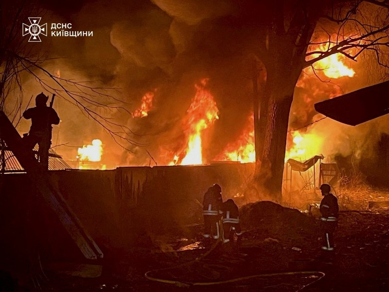 Seorang petugas pemadam kebakaran bekerja di lokasi gedung apartemen yang terkena serangan pesawat nirawak Rusia, di tengah serangan Rusia terhadap Ukraina, di Kyiv, Ukraina, 23 Maret 2025. (via REUTERS/STATE EMERGENCY SERVICE OF UKRAI)