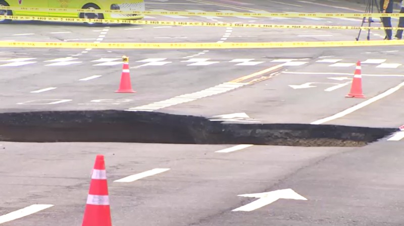 Emergency workers stand near a sinkhole in a road, in Seoul, South Korea, March 25, 2025. Yonhap via REUTERS