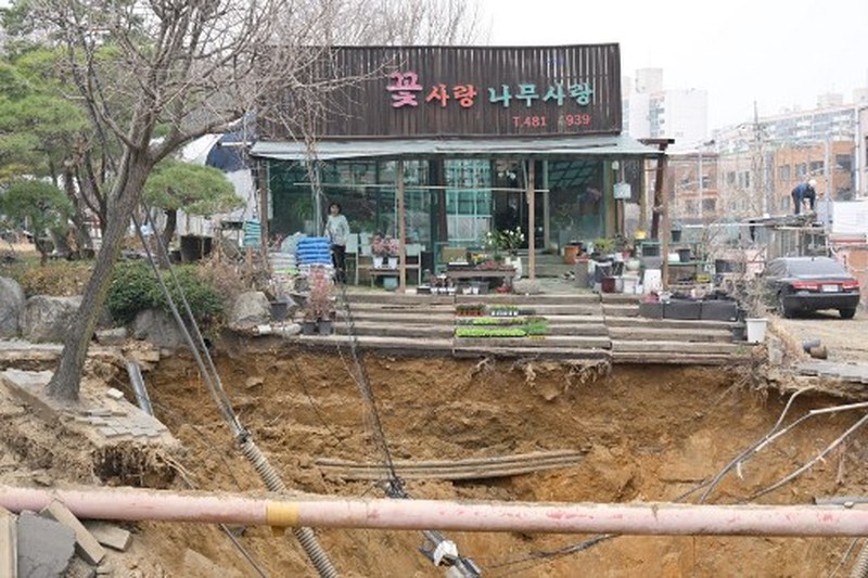 Emergency workers stand near a sinkhole in a road, in Seoul, South Korea, March 25, 2025. Yonhap via REUTERS