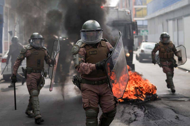 CHILE-PROTEST/FISHING Police officers walk as they hold their shields during a protest against a law being debated that would increase quotas for industrial fishing companies, in Valparaiso Chile March 25, 2025. REUTERS/Pablo Sanhueza TPX IMAGES OF THE DAY
