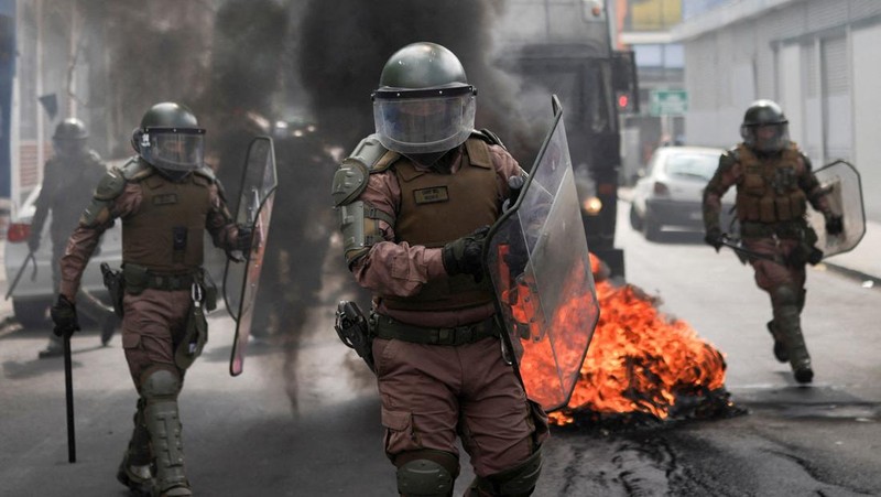 Police officers walk as they hold their shields during a protest against a law being debated that would increase quotas for industrial fishing companies, in Valparaiso Chile March 25, 2025. REUTERS/Pablo Sanhueza     TPX IMAGES OF THE DAY