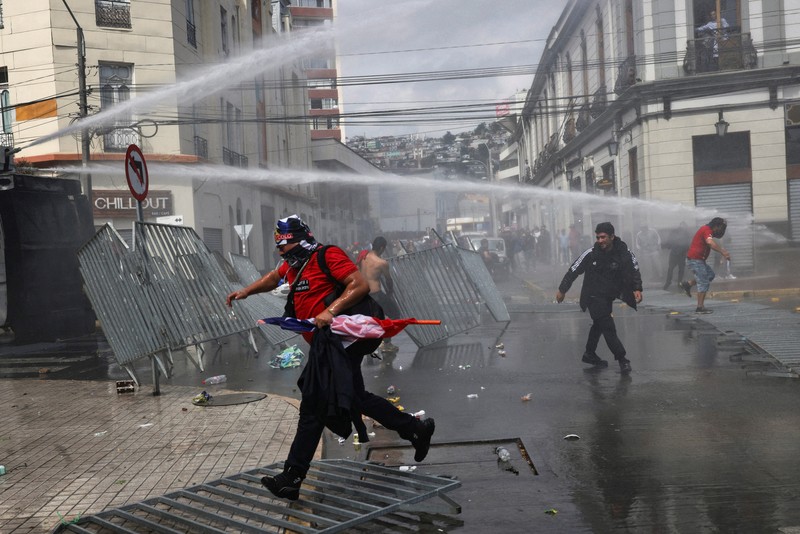Police officers walk as they hold their shields during a protest against a law being debated that would increase quotas for industrial fishing companies, in Valparaiso Chile March 25, 2025. REUTERS/Pablo Sanhueza     TPX IMAGES OF THE DAY