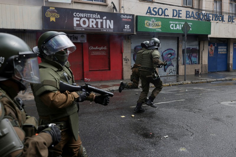Police officers walk as they hold their shields during a protest against a law being debated that would increase quotas for industrial fishing companies, in Valparaiso Chile March 25, 2025. REUTERS/Pablo Sanhueza     TPX IMAGES OF THE DAY