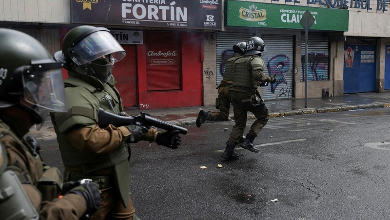 Police officers walk as they hold their shields during a protest against a law being debated that would increase quotas for industrial fishing companies, in Valparaiso Chile March 25, 2025. REUTERS/Pablo Sanhueza     TPX IMAGES OF THE DAY