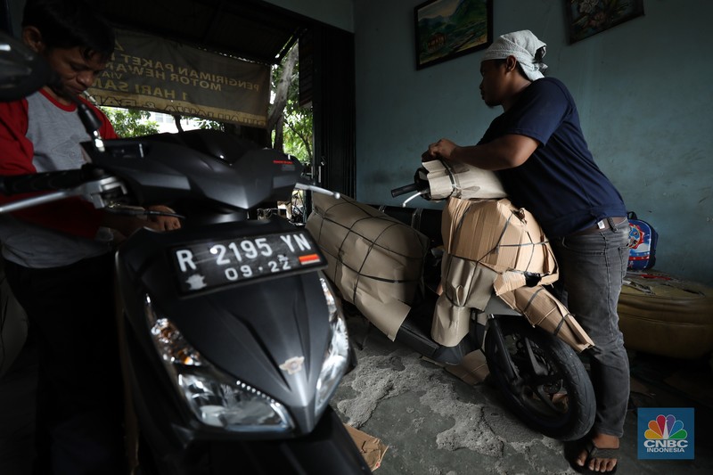 Pekerja membungkus sepeda motor dengan kardus di jasa pengiriman barang di kawasan Pasar Senen, Jakarta, Rabu (26/3/2025). Pekerja membungkus sepeda motor dengan kardus di jasa pengiriman barang di kawasan Pasar Senen, Jakarta, Rabu (26/3/2025). (²©²ÊÍøÕ¾/Tri Susilo)