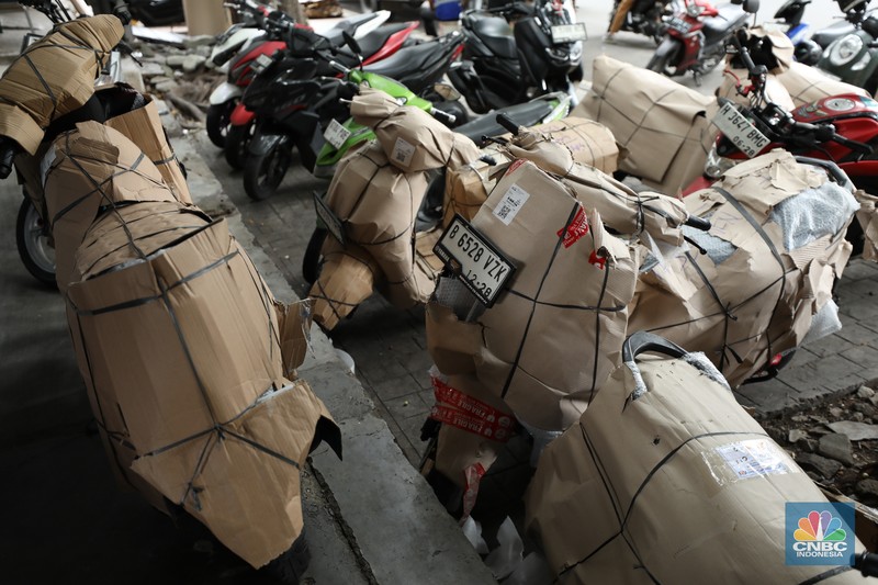 Pekerja membungkus sepeda motor dengan kardus di jasa pengiriman barang di kawasan Pasar Senen, Jakarta, Rabu (26/3/2025). Pekerja membungkus sepeda motor dengan kardus di jasa pengiriman barang di kawasan Pasar Senen, Jakarta, Rabu (26/3/2025). (²©²ÊÍøÕ¾/Tri Susilo)