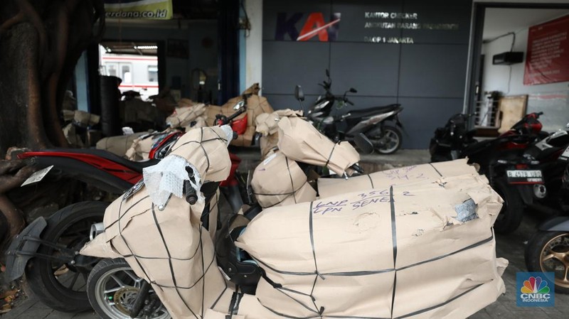Pekerja membungkus sepeda motor dengan kardus di jasa pengiriman barang di kawasan Pasar Senen, Jakarta, Rabu (26/3/2025). (վ/Tri Susilo)