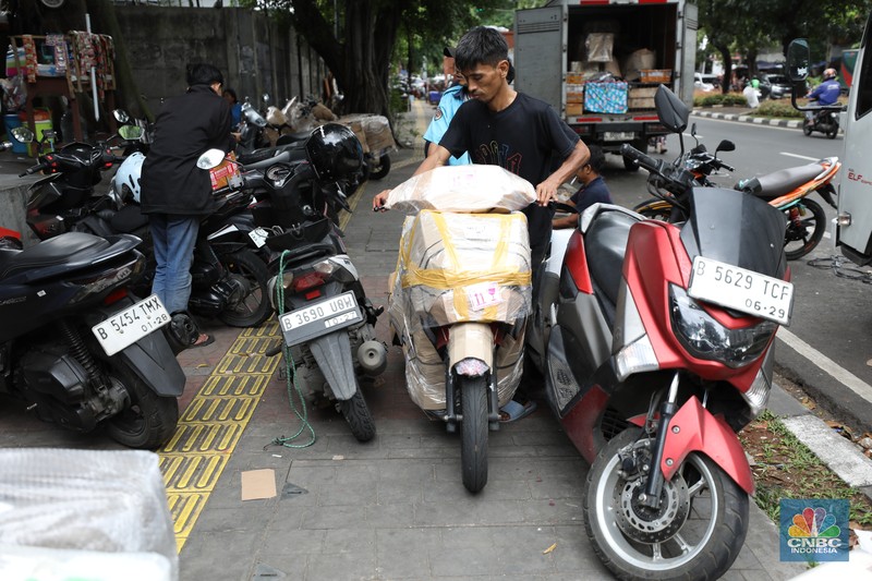 Pekerja membungkus sepeda motor dengan kardus di jasa pengiriman barang di kawasan Pasar Senen, Jakarta, Rabu (26/3/2025). Pekerja membungkus sepeda motor dengan kardus di jasa pengiriman barang di kawasan Pasar Senen, Jakarta, Rabu (26/3/2025). (²©²ÊÍøÕ¾/Tri Susilo)