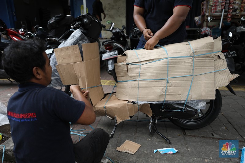 Pekerja membungkus sepeda motor dengan kardus di jasa pengiriman barang di kawasan Pasar Senen, Jakarta, Rabu (26/3/2025). Pekerja membungkus sepeda motor dengan kardus di jasa pengiriman barang di kawasan Pasar Senen, Jakarta, Rabu (26/3/2025). (²©²ÊÍøÕ¾/Tri Susilo)