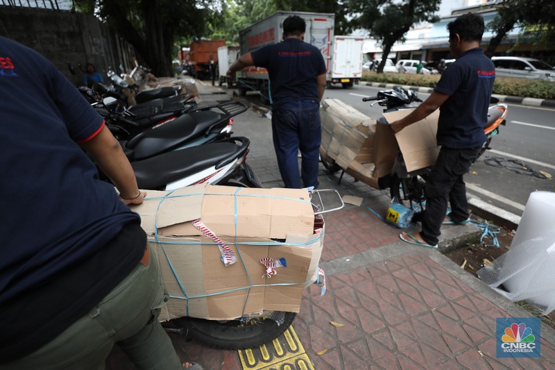 Pekerja membungkus sepeda motor dengan kardus di jasa pengiriman barang di kawasan Pasar Senen, Jakarta, Rabu (26/3/2025). Pekerja membungkus sepeda motor dengan kardus di jasa pengiriman barang di kawasan Pasar Senen, Jakarta, Rabu (26/3/2025). (²©²ÊÍøÕ¾/Tri Susilo)