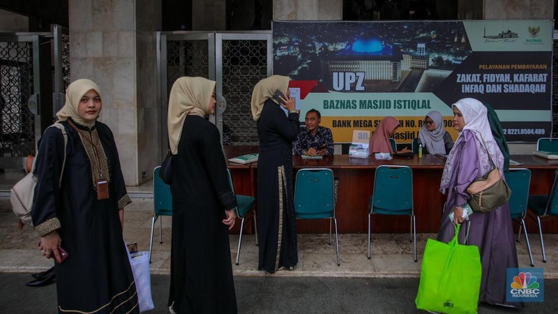 Petugas amil zakat melayani warga yang ingin membayar zakat fitrah di Masjid Istiqlal, Jakarta, Rabu (26/3/2025). (վ/Faisal Rahman)