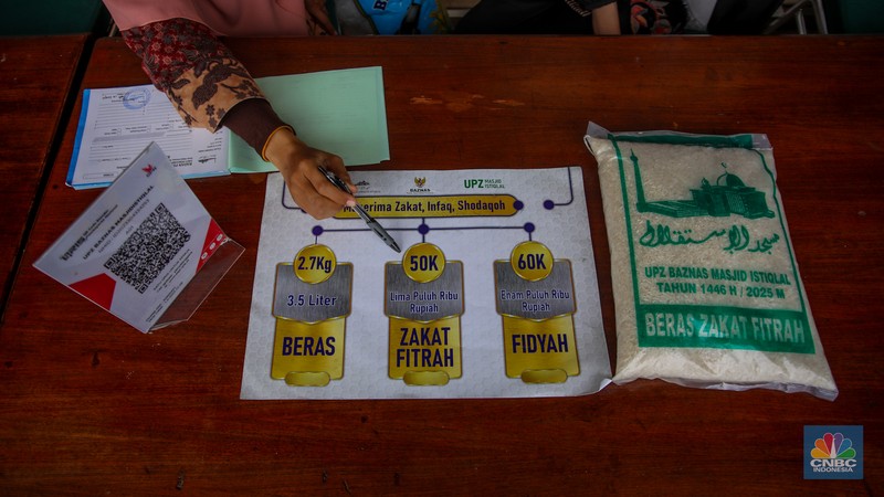 Petugas amil zakat melayani warga yang ingin membayar zakat fitrah di Masjid Istiqlal, Jakarta, Rabu (26/3/2025). (CNBC Indonesia/Faisal Rahman)