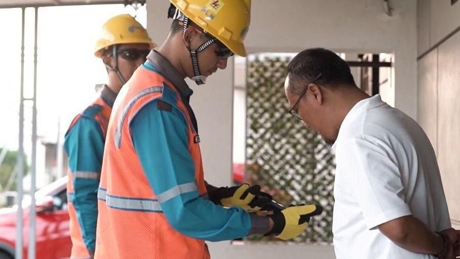 Ilustrasi petugas PLN telah menyelesaikan perbaikan gangguan dan menjelaskan berbagai fitur pada Aplikasi PLN Mobile kepada pelanggan. (Dok. PT PLN (Persero))