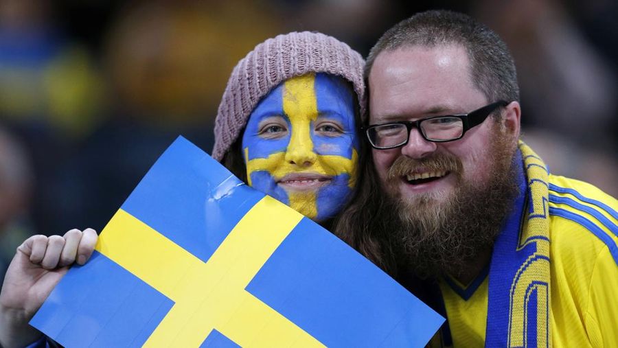 Warga Swedia berpose dengan bendera Swedia. (AP Photo/Frank Augstein/file Foto)