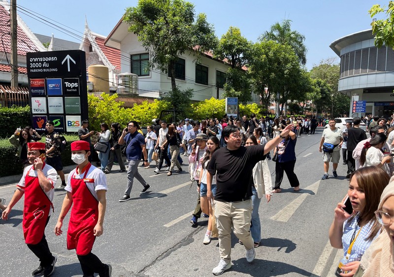 Orang-orang keluar gedung setelah gempa bumi dahsyat yang melanda Myanmar tengah pada hari Jumat menghantam Bangkok, di Bangkok, Thailand 28 Maret 2025. (REUTERS/Cherng Kerk Chon)