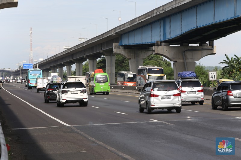 Puncak arus mudik masih berlangsung pada H-2 Lebaran 2025. Situasi lalu lintas di Ruas Tol Jakarta-Cikampek, khususnya di KM 41 arah Cikarang Barat, terpantau padat merayap pada siang hari, Selasa (8/4/2025). (CNBC Indonesia/Tias Budiarto)