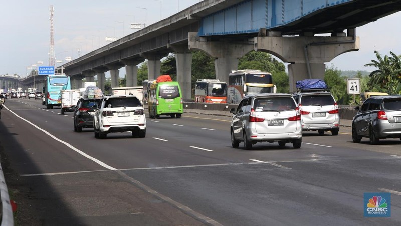 Puncak arus mudik masih berlangsung pada H-2 Lebaran 2025. Situasi lalu lintas di Ruas Tol Jakarta-Cikampek, khususnya di KM 41 arah Cikarang Barat, terpantau padat merayap pada siang hari, Selasa (8/4/2025). (CNBC Indonesia/Tias Budiarto)