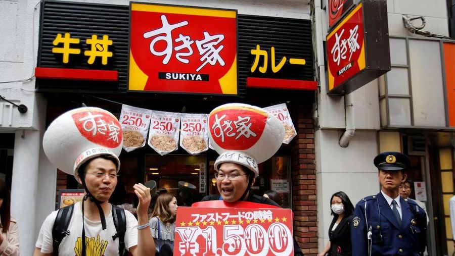 Demonstran mengenakan topi yang menampilkan mangkuk daging sapi dari restoran cepat saji Sukiya, ikut serta dalam protes untuk menuntut upah yang lebih tinggi bagi pekerja makanan cepat saji di depan restoran Sukiya di distrik perbelanjaan dan hiburan Shibuya, Tokyo, 15 Mei 2014. (REUTERS/Toru Hanai)