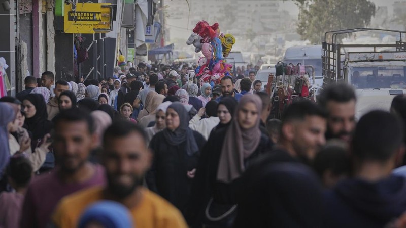 Perempuan Palestina yang mengungsi menyiapkan penganan tradisional untuk hari raya Idul Fitri yang menandai berakhirnya bulan puasa Ramadan, di Khan Younis di Jalur Gaza selatan pada 29 Maret 2025. (REUTERS/Hatem Khaled)