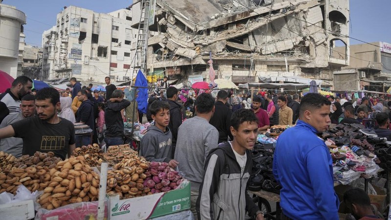 Perempuan Palestina yang mengungsi menyiapkan penganan tradisional untuk hari raya Idul Fitri yang menandai berakhirnya bulan puasa Ramadan, di Khan Younis di Jalur Gaza selatan pada 29 Maret 2025. (REUTERS/Hatem Khaled)