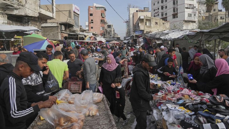 Perempuan Palestina yang mengungsi menyiapkan penganan tradisional untuk hari raya Idul Fitri yang menandai berakhirnya bulan puasa Ramadan, di Khan Younis di Jalur Gaza selatan pada 29 Maret 2025. (REUTERS/Hatem Khaled)