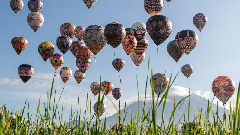 Foto udara menampilkan balon udara yang terbuat dari kertas daur ulang saat festival balon udara tahunan di Wonosobo, Jawa Tengah, Rabu (2/4/2025). (DEVI RAHMAN / AFP)