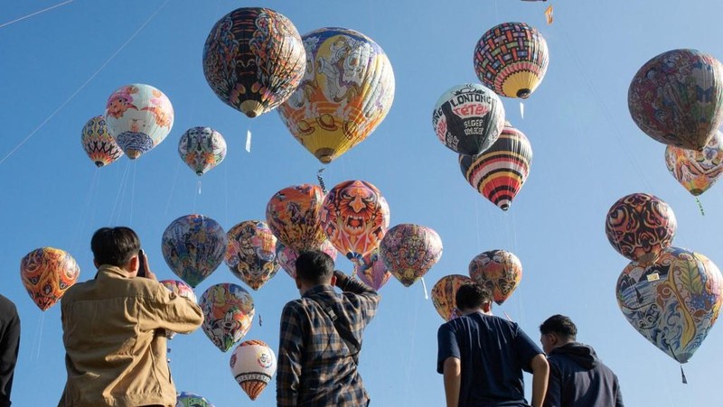 Foto udara menampilkan balon udara yang terbuat dari kertas daur ulang saat festival balon udara tahunan di Wonosobo, Jawa Tengah, Rabu (2/4/2025). (DEVI RAHMAN / AFP)