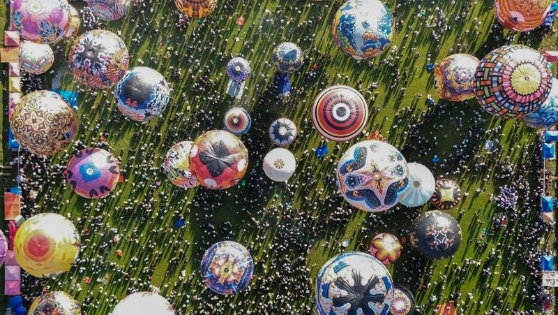 Foto udara menampilkan balon udara yang terbuat dari kertas daur ulang saat festival balon udara tahunan di Wonosobo, Jawa Tengah, Rabu (2/4/2025). (DEVI RAHMAN / AFP)