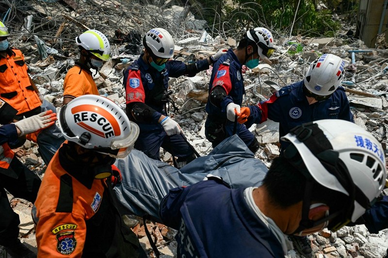 Tim penyelamat Myanmar dan Tiongkok membawa jenazah korban yang terjebak di bawah reruntuhan bangunan yang runtuh 'Sky Villa Condominium development' di Mandalay, Myanmar, Rabu (2/4/2025). (Sai Aung MAIN / AFP) Tim penyelamat Myanmar dan Tiongkok membawa jenazah korban yang terjebak di bawah reruntuhan bangunan yang runtuh 'Sky Villa Condominium development' di Mandalay, Myanmar, Rabu (2/4/2025). (Sai Aung MAIN / AFP)