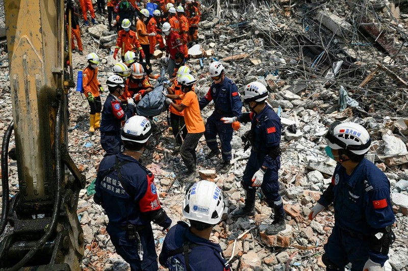 Tim penyelamat Myanmar dan Tiongkok membawa jenazah korban yang terjebak di bawah reruntuhan bangunan yang runtuh 'Sky Villa Condominium development' di Mandalay, Myanmar, Rabu (2/4/2025). (Sai Aung MAIN / AFP) Tim penyelamat Myanmar dan Tiongkok membawa jenazah korban yang terjebak di bawah reruntuhan bangunan yang runtuh 'Sky Villa Condominium development' di Mandalay, Myanmar, Rabu (2/4/2025). (Sai Aung MAIN / AFP)
