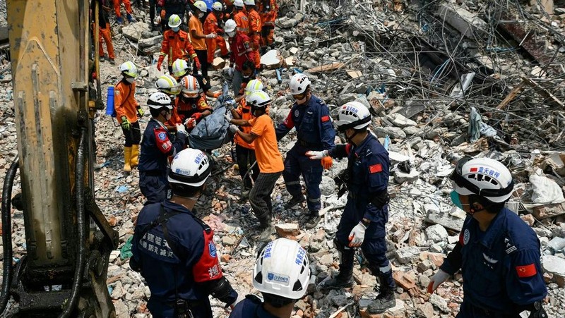 Tim penyelamat Myanmar dan Tiongkok membawa jenazah korban yang terjebak di bawah reruntuhan bangunan yang runtuh 'Sky Villa Condominium development' di Mandalay, Myanmar, Rabu (2/4/2025). (Sai Aung MAIN / AFP)