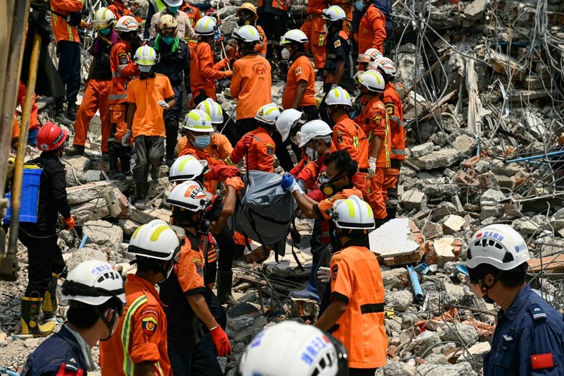 Tim penyelamat Myanmar dan Tiongkok membawa jenazah korban yang terjebak di bawah reruntuhan bangunan yang runtuh 'Sky Villa Condominium development' di Mandalay, Myanmar, Rabu (2/4/2025). (Sai Aung MAIN / AFP)