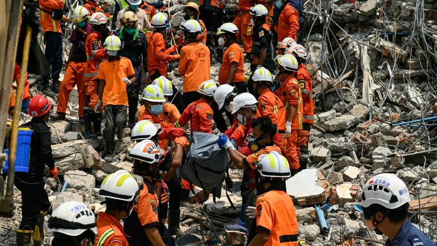 Tim penyelamat Myanmar dan Tiongkok membawa jenazah korban yang terjebak di bawah reruntuhan bangunan yang runtuh 'Sky Villa Condominium development' di Mandalay, Myanmar, Rabu (2/4/2025). (Sai Aung MAIN / AFP)