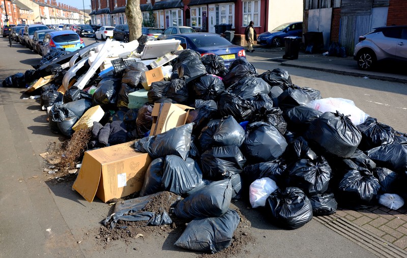 Seorang anak sekolah menutup hidungnya karena mencium bau tumpukan sampah yang menghalangi trotoar, saat aksi mogok pekerja tempat sampah Birmingham yang diwakili oleh serikat pekerja Unite memasuki minggu keempat, di Sparkhill, Birmingham, Inggris, 2 April 2025. Seorang anak sekolah menutup hidungnya karena mencium bau tumpukan sampah yang menghalangi trotoar, saat aksi mogok pekerja tempat sampah Birmingham yang diwakili oleh serikat pekerja Unite memasuki minggu keempat, di Sparkhill, Birmingham, Inggris, 2 April 2025. (REUTERS/Jaimi Joy)