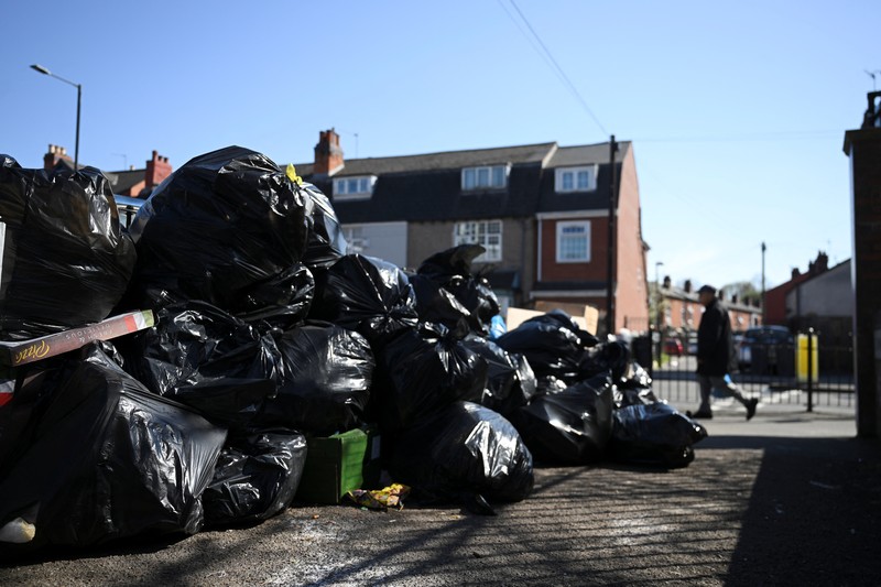 Seorang anak sekolah menutup hidungnya karena mencium bau tumpukan sampah yang menghalangi trotoar, saat aksi mogok pekerja tempat sampah Birmingham yang diwakili oleh serikat pekerja Unite memasuki minggu keempat, di Sparkhill, Birmingham, Inggris, 2 April 2025. Seorang anak sekolah menutup hidungnya karena mencium bau tumpukan sampah yang menghalangi trotoar, saat aksi mogok pekerja tempat sampah Birmingham yang diwakili oleh serikat pekerja Unite memasuki minggu keempat, di Sparkhill, Birmingham, Inggris, 2 April 2025. (REUTERS/Jaimi Joy)