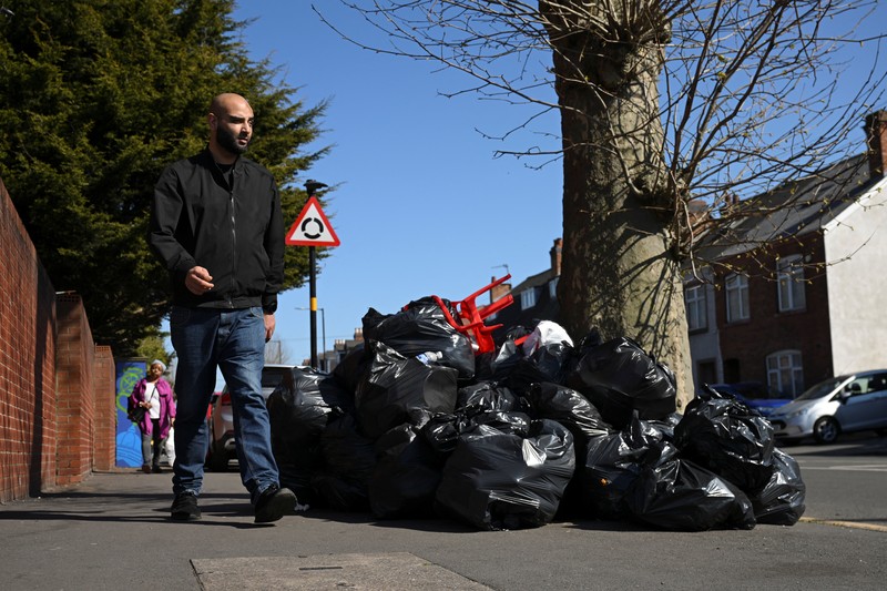 Seorang anak sekolah menutup hidungnya karena mencium bau tumpukan sampah yang menghalangi trotoar, saat aksi mogok pekerja tempat sampah Birmingham yang diwakili oleh serikat pekerja Unite memasuki minggu keempat, di Sparkhill, Birmingham, Inggris, 2 April 2025. Seorang anak sekolah menutup hidungnya karena mencium bau tumpukan sampah yang menghalangi trotoar, saat aksi mogok pekerja tempat sampah Birmingham yang diwakili oleh serikat pekerja Unite memasuki minggu keempat, di Sparkhill, Birmingham, Inggris, 2 April 2025. (REUTERS/Jaimi Joy)