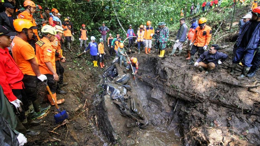 Rescuers search for victims after a rain-triggered landslide hit passing cars on a road in Mojokerto, East Java, Indonesia, Friday, April 4, 2025. (AP Photo)