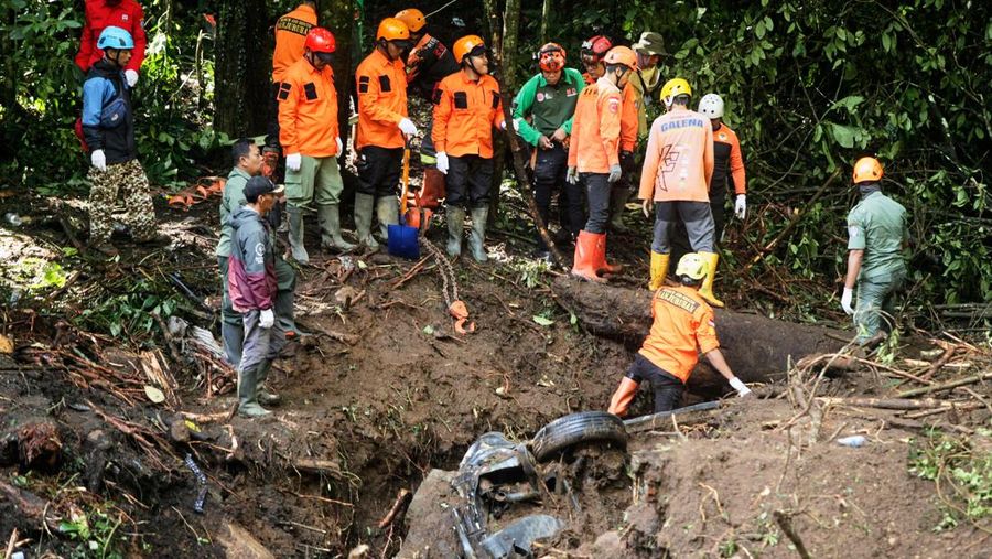 Rescuers search for victims after a rain-triggered landslide hit passing cars on a road in Mojokerto, East Java, Indonesia, Friday, April 4, 2025. (AP Photo)