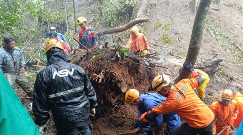 Rescuers search for victims after a rain-triggered landslide hit passing cars on a road in Mojokerto, East Java, Indonesia, Friday, April 4, 2025. (AP Photo)