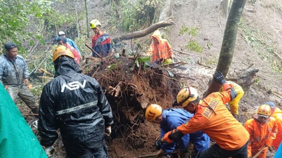 Rescuers search for victims after a rain-triggered landslide hit passing cars on a road in Mojokerto, East Java, Indonesia, Friday, April 4, 2025. (AP Photo)